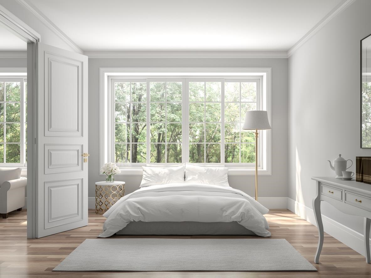 Bedroom with all white walls, furniture, and bedding. 