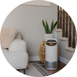 TruSens Air Purifier in a home next to a couch and set of stairs.